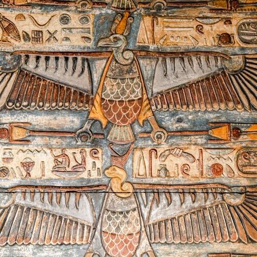 Ancient Egyptian fresco depicting a symmetrical bird figure with widespread wings, adorned with detailed hieroglyphics and colorful motifs.