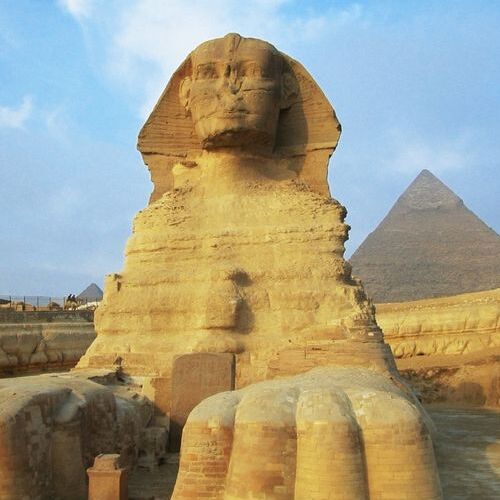 A close-up of the Great Sphinx with the Pyramid of Khafre in the background at Giza, Cairo, Egypt
