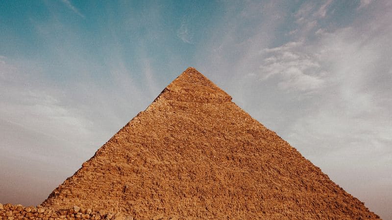 Upward view of the Great Pyramid of Giza against a clear sky