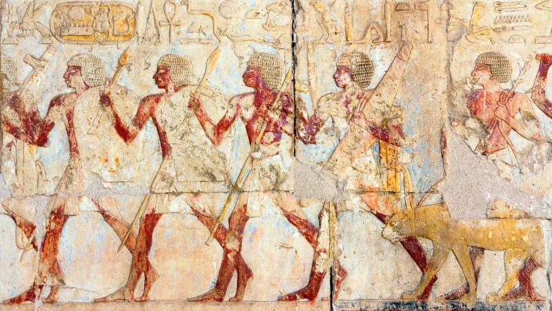 Ancient Egyptian wall painting depicting a procession with figures and animals.