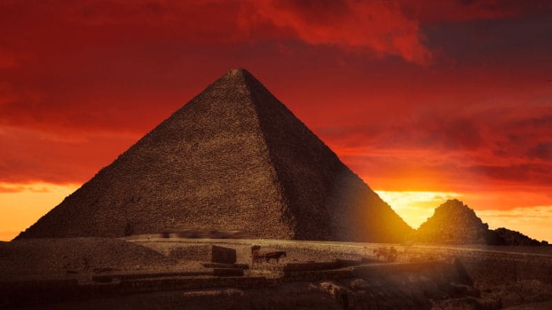 The Great Pyramid of Giza against a dramatic red sunset sky