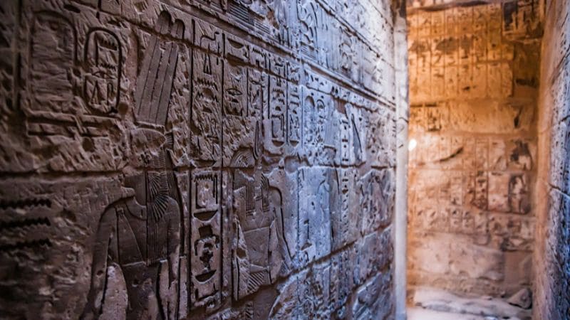 Close-up of intricate hieroglyphs carved into the wall of an Egyptian temple