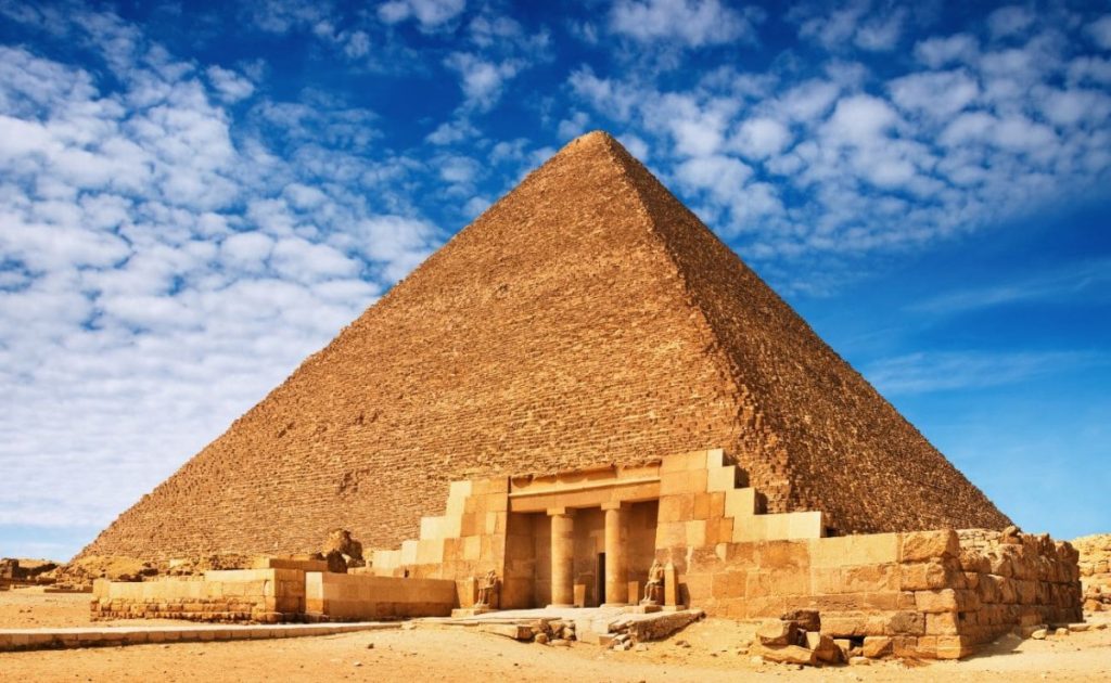 The Pyramid of Khafre under a vivid blue sky, with an ancient temple in the foreground
