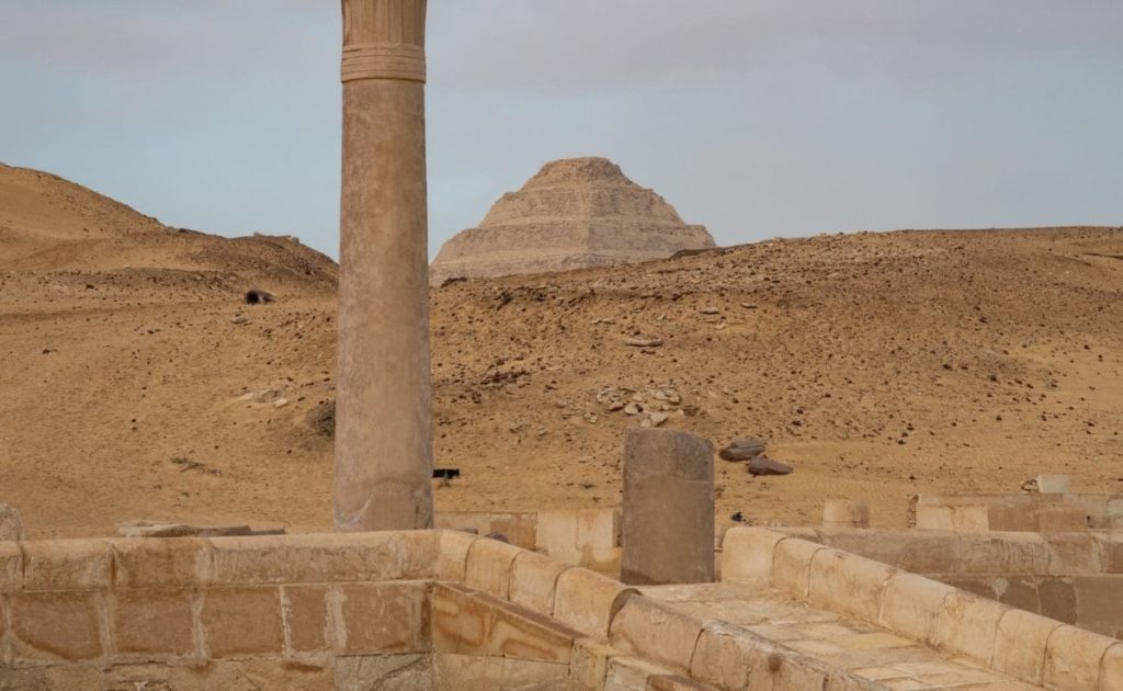 View of the Step Pyramid of Djoser through ancient ruins in Saqqara, Egypt