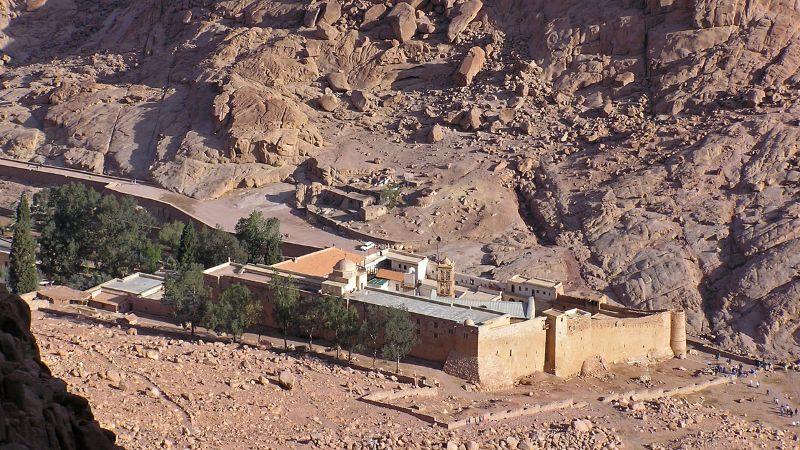 A distant view of St. Catherine's Monastery nestled at the base of a rugged mountain in Sinai, Egypt.