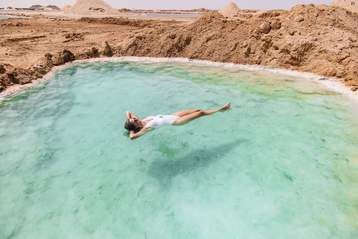 Crystal clear salt pools in Siwa Oasis under a vibrant blue sky