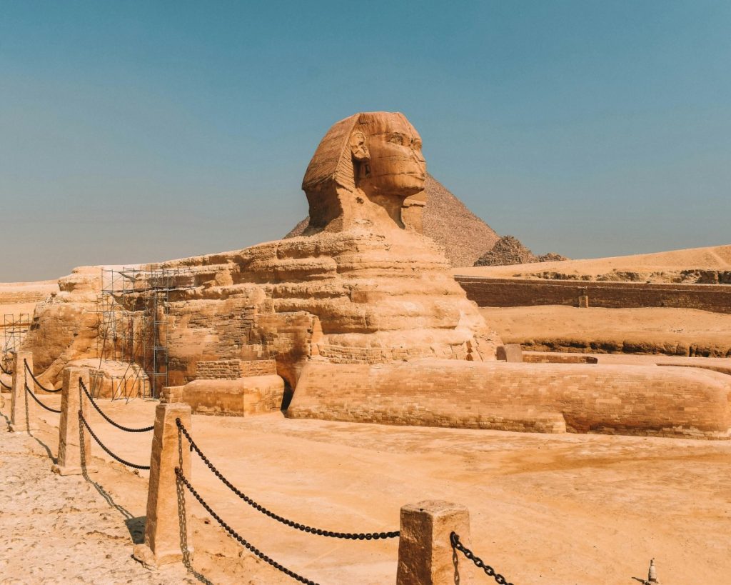 The Great Sphinx of Giza with the Pyramid of Khafre in the background under a clear blue sky