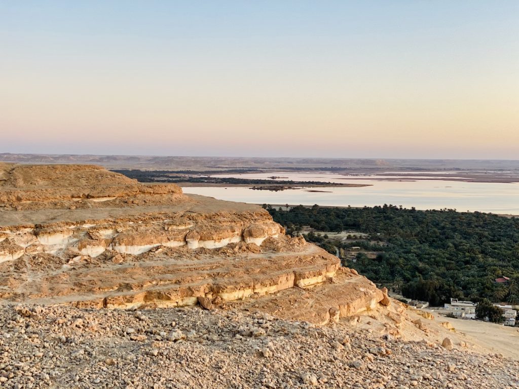 Sunset view from Gabal Dakrour showing the serene landscape with Siwa Oasis and the surrounding desert.