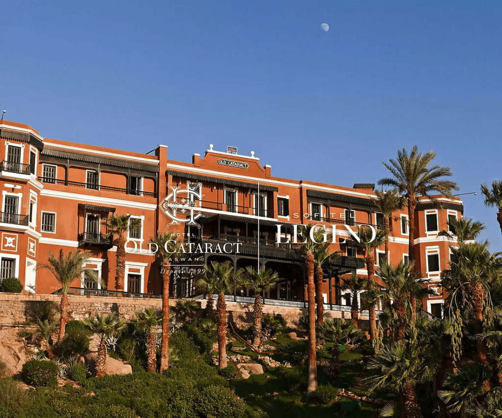 View of The Old Cataract Hotel in Aswan, featuring its classic facade with grand arches and colonial architecture overlooking the Nile.