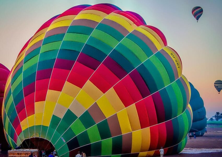 Colorful hot air balloons soaring over Luxor's ancient landscape at sunrise