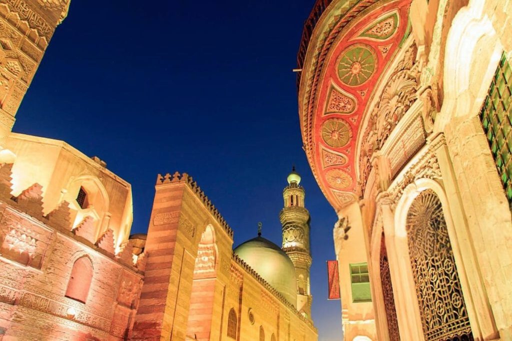 Illuminated minarets and domes of a mosque in Cairo at night