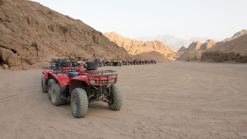 Row of quad bikes parked in a desert valley