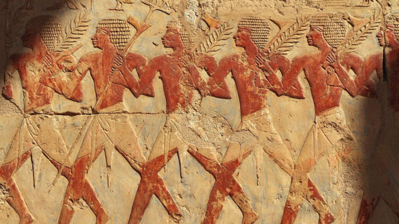 Ancient Egyptian relief depicting men holding branches.