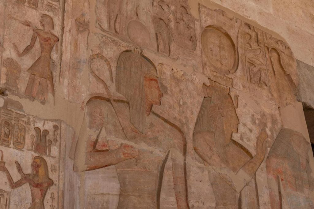 Ancient Egyptian wall carvings depicting detailed scenes of daily life and religious rituals