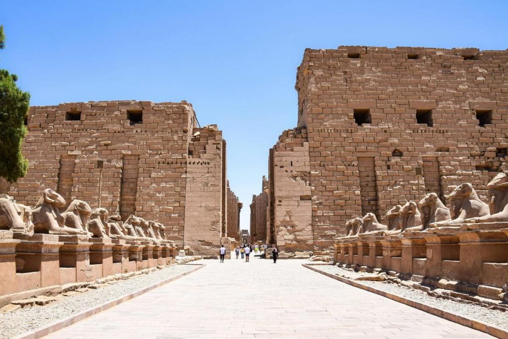 Avenue of Sphinxes leading to the Karnak Temple in Egypt, lined with rows of majestic stone sphinxes under a clear blue sky