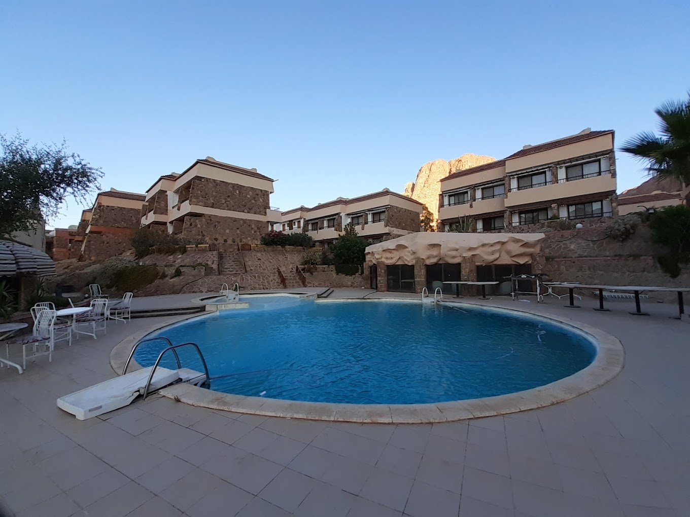 A serene view of the Catherine Plaza Hotel's exterior with a backdrop of mountains