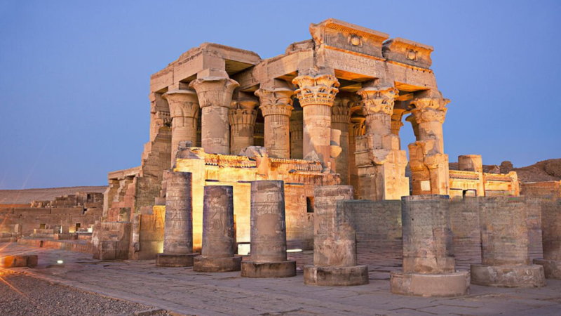 The illuminated Kom Ombo Temple at dusk, highlighting its ancient columns and intricate carvings.