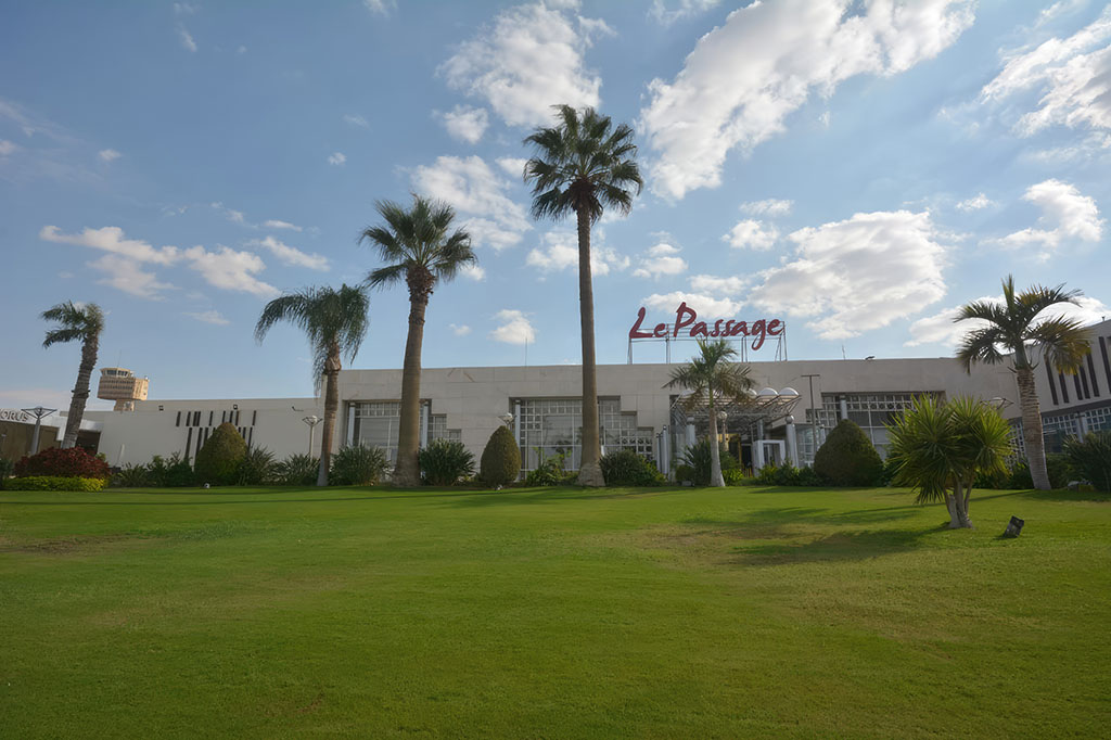 Le Passage Cairo Hotel with a luxurious pool area and lush green surroundings