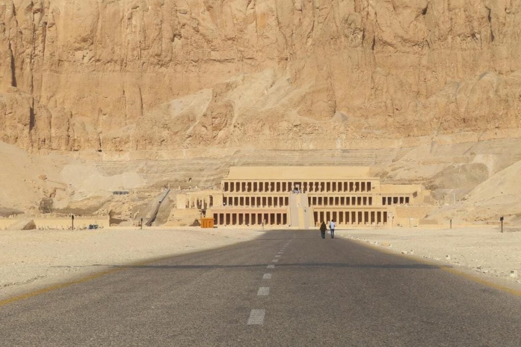 View of the Temple of Hatshepsut nestled against towering cliffs in Luxor, Egypt.