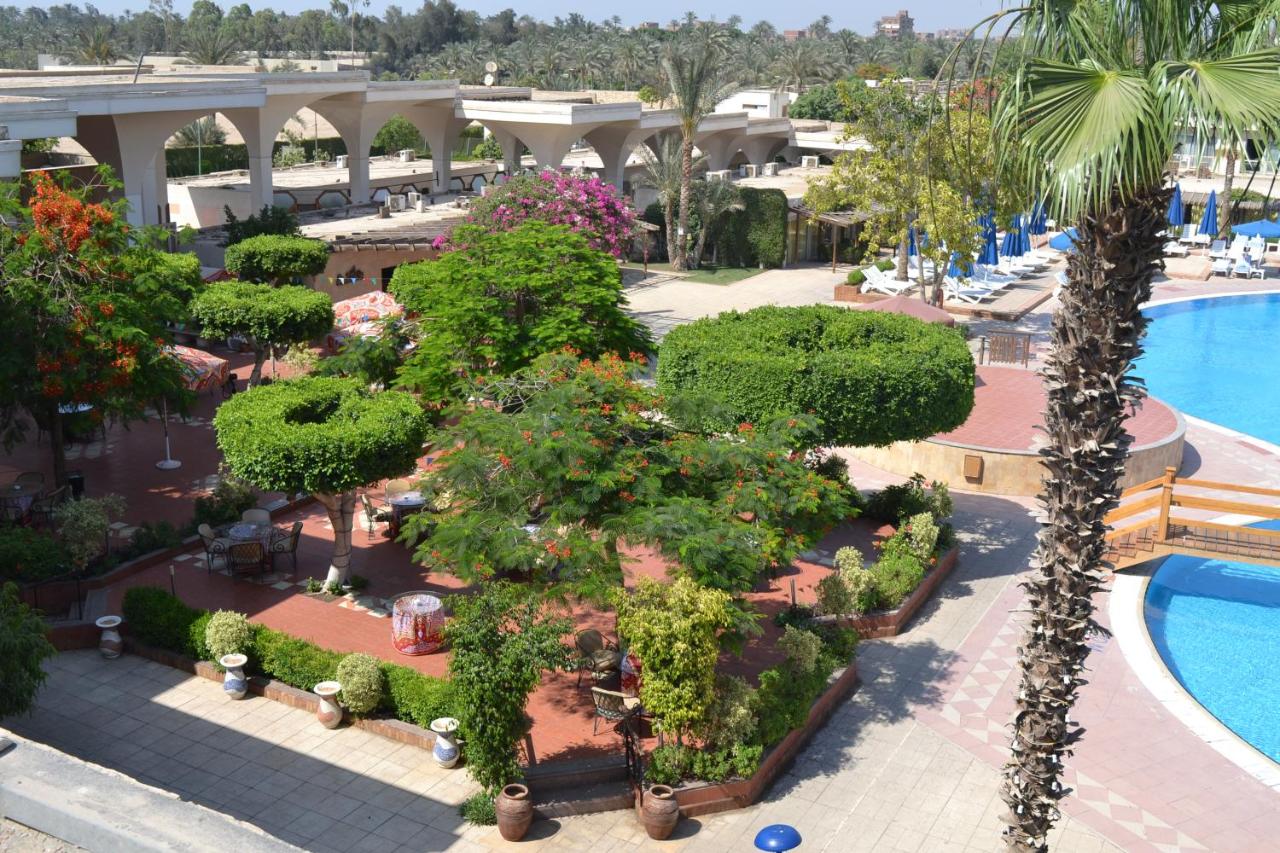 Pyramids Park Resort Cairo with a large pool area surrounded by lush gardens