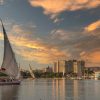 Traditional sailboats on the Nile River at sunset with a city skyline in the background.