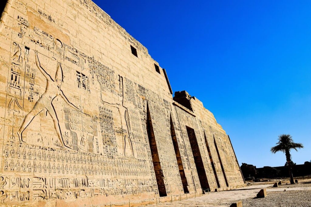 Detailed carvings on the walls of an ancient Egyptian temple, depicting various scenes and hieroglyphics.