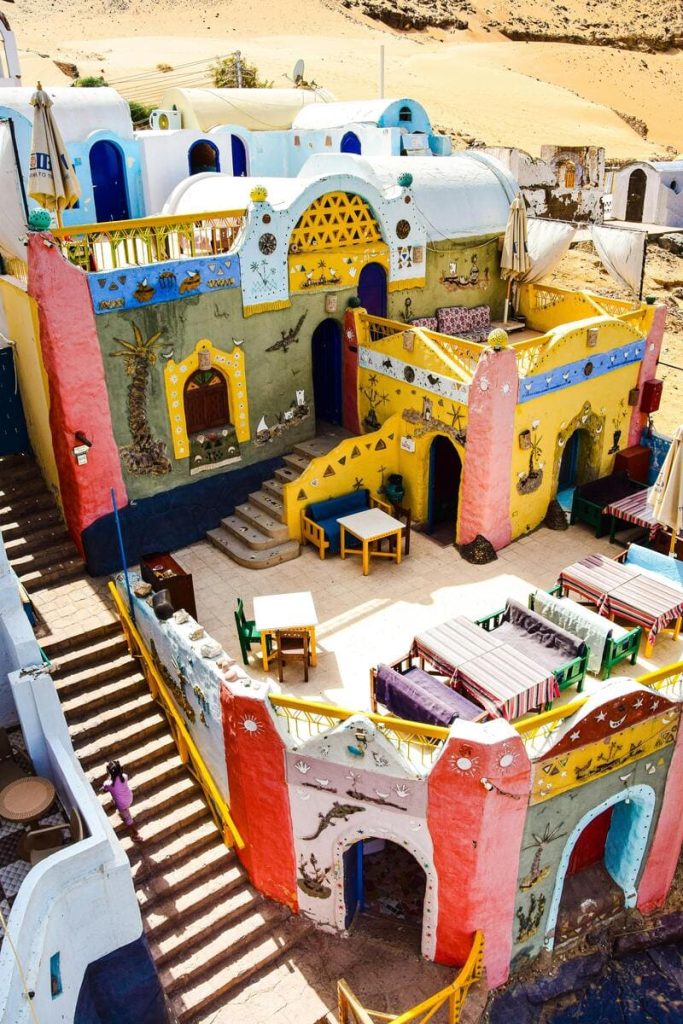 Colorful Nubian village houses with vibrant murals and outdoor seating in Aswan, Egypt