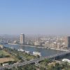 A vibrant downtown scene in Cairo with modern buildings, bustling streets, and a mix of traditional and contemporary architecture under a clear blue sky