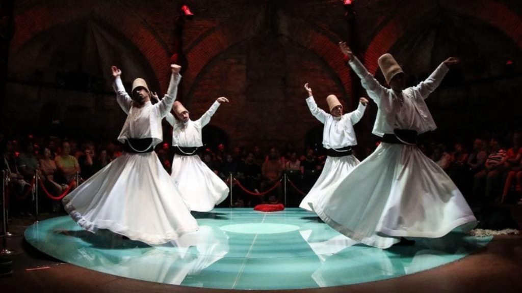 Sufi dancers performing a whirling dervish dance in traditional white garments