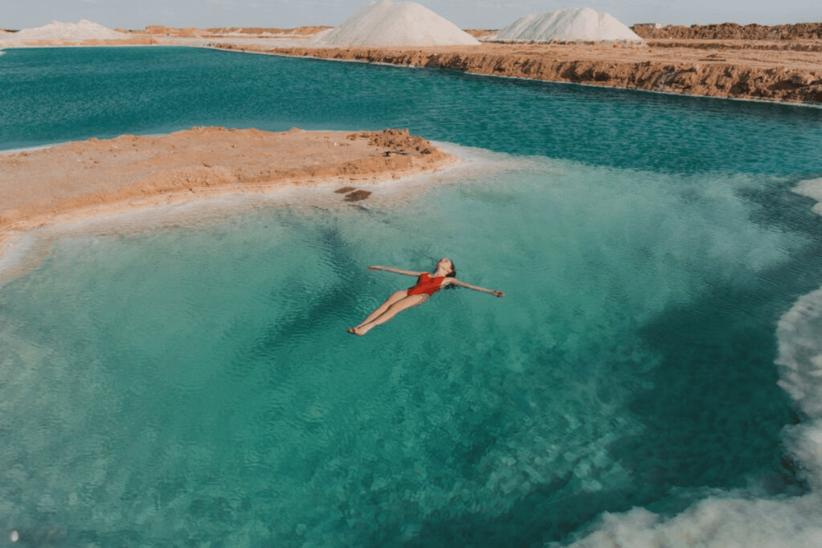 Pristine salt lake in Siwa Oasis, Egypt, with crystal-clear turquoise water surrounded by arid desert landscapes