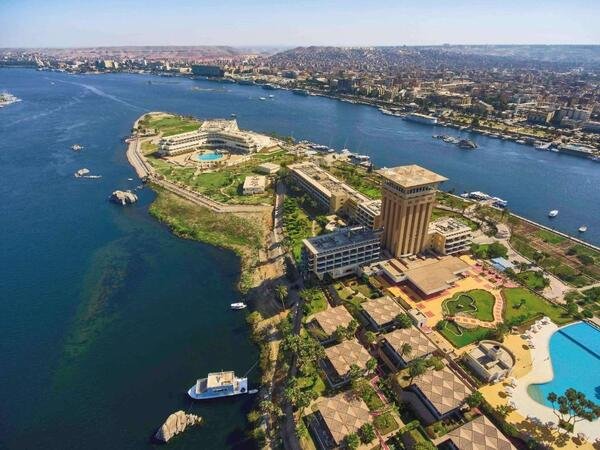 Mövenpick Resort Aswan, a luxurious riverside hotel with elegant architecture, surrounded by lush gardens and offering stunning Nile views