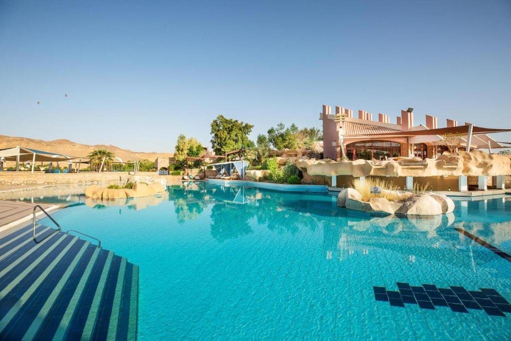 Isis Island Resort, a serene riverside retreat in Aswan, featuring lush gardens and a stunning view of the Nile River