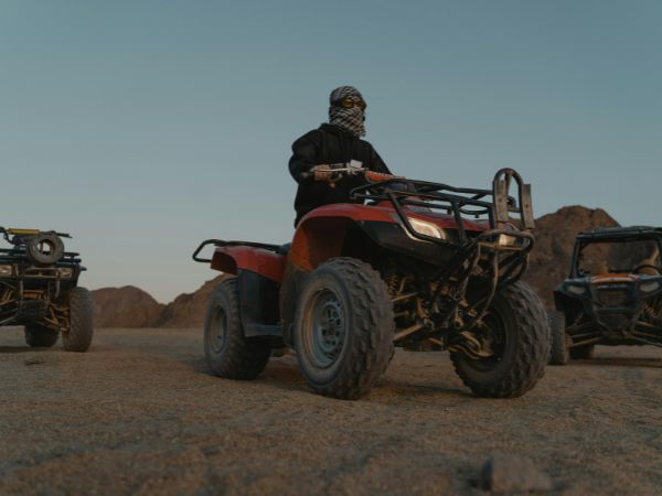 A desert scene with a quad bike in Sharm El Sheikh surrounded by mountains at sunset