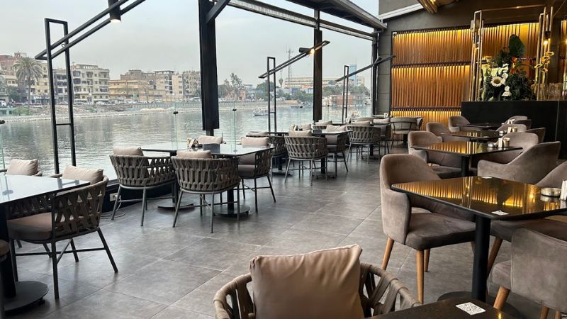 Indoor restaurant with modern decor and large windows offering a view of the Nile River