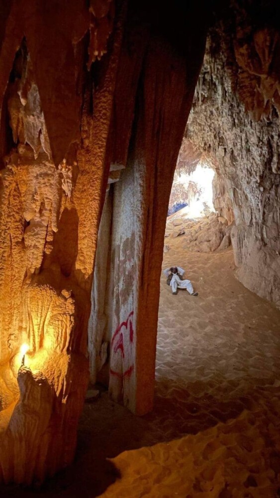 Inside a cave with dramatic rock formations illuminated by light