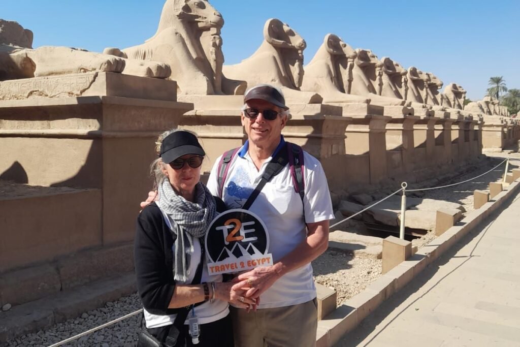Tourists posing in front of the Avenue of the Sphinxes at Karnak Temple in Egypt