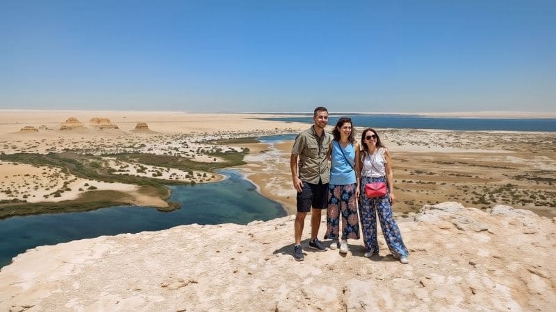 A breathtaking view of a desert lake in Egypt, surrounded by golden sand dunes and serene blue waters