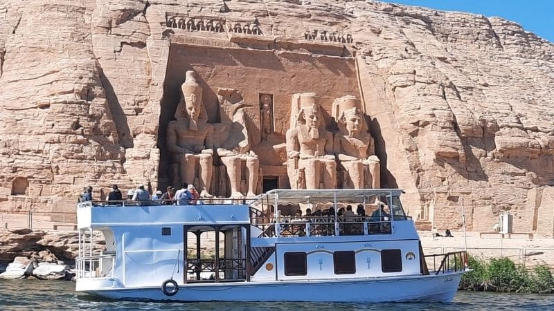 A two-level riverboat cruising past the impressive Abu Simbel Temples on Lake Nasser