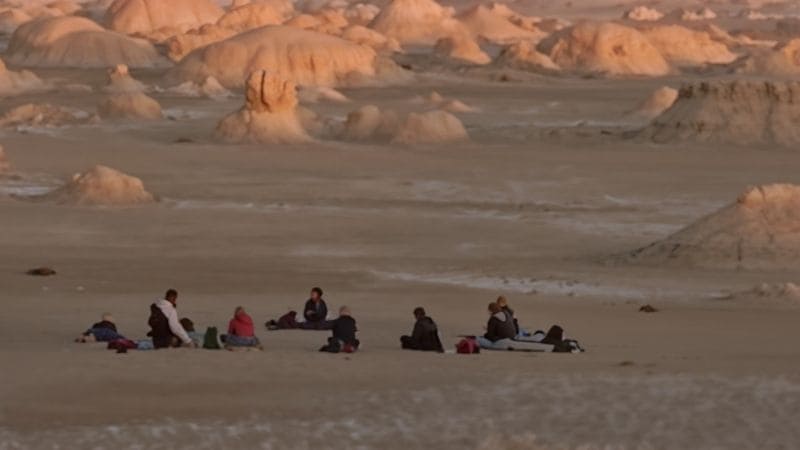 A breathtaking sunset over Egypt's White Desert, with dramatic white rock formations glowing in golden and pink hues