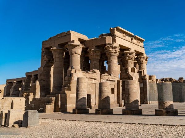 The ancient Temple of Kom Ombo, featuring large columns and intricate carvings under a bright blue sky