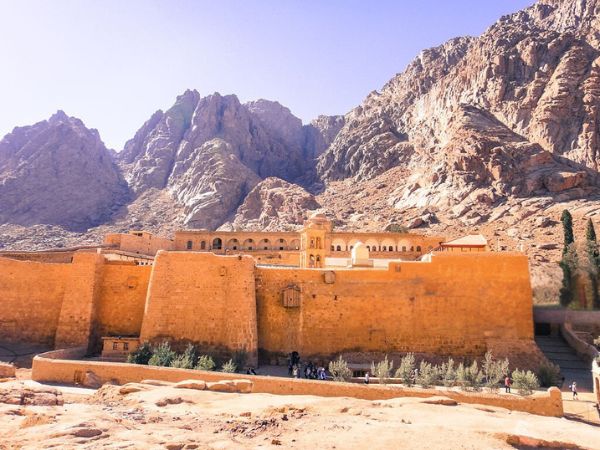 The historic St. Catherine’s Monastery nestled at the foot of rugged mountains under a bright sky