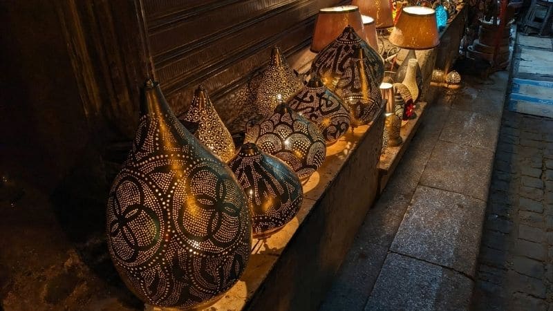 Traditional Egyptian metal lanterns with intricate patterns glowing at a nighttime market