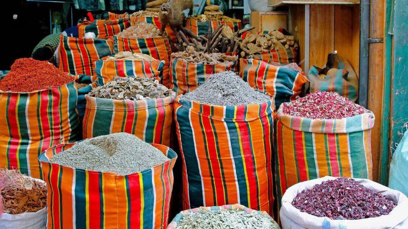 Bags filled with colorful spices, herbs, and dried flowers in a traditional Egyptian market