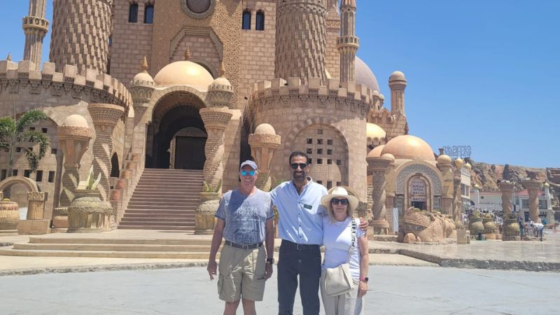 Beautiful mosque with intricate domes and minarets in Sharm El-Sheikh, Egypt, set against a clear blue sky, with visitors walking in the foreground