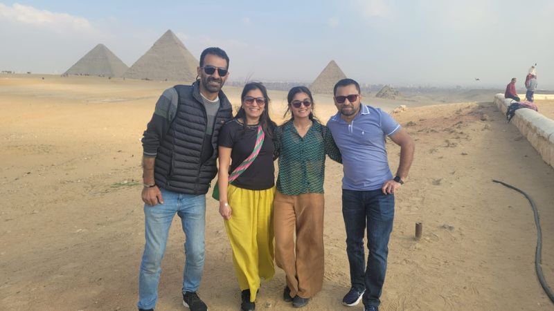 A group of women posing with the Pyramids of Giza in the background