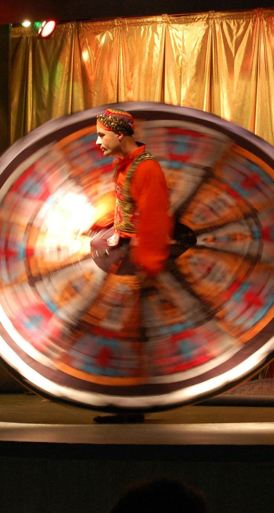 Traditional Egyptian Tanoura dancer performing in vibrant colorful attire with swirling movements