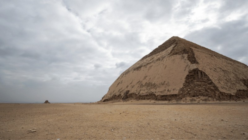 The Bent Pyramid of Dahshur Egypt standing against a clear sky showcasing its unique architectural design and smooth limestone casing