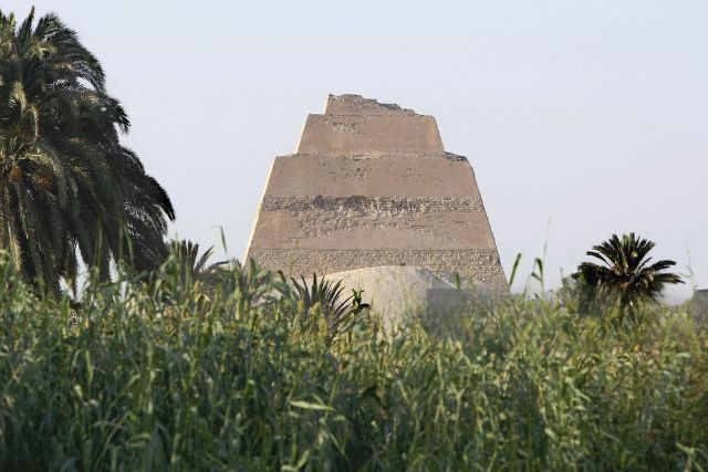 ancient pyramid structure partially buried in greenery