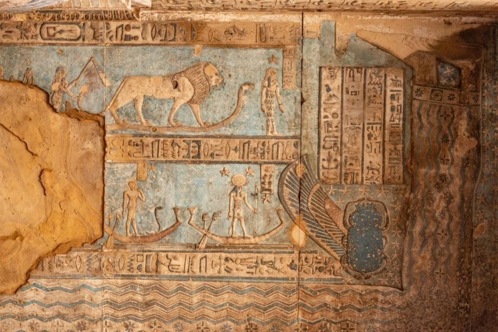 Ceiling artwork from the tomb of Seti I showing lions serpents solar boats and hieroglyphs