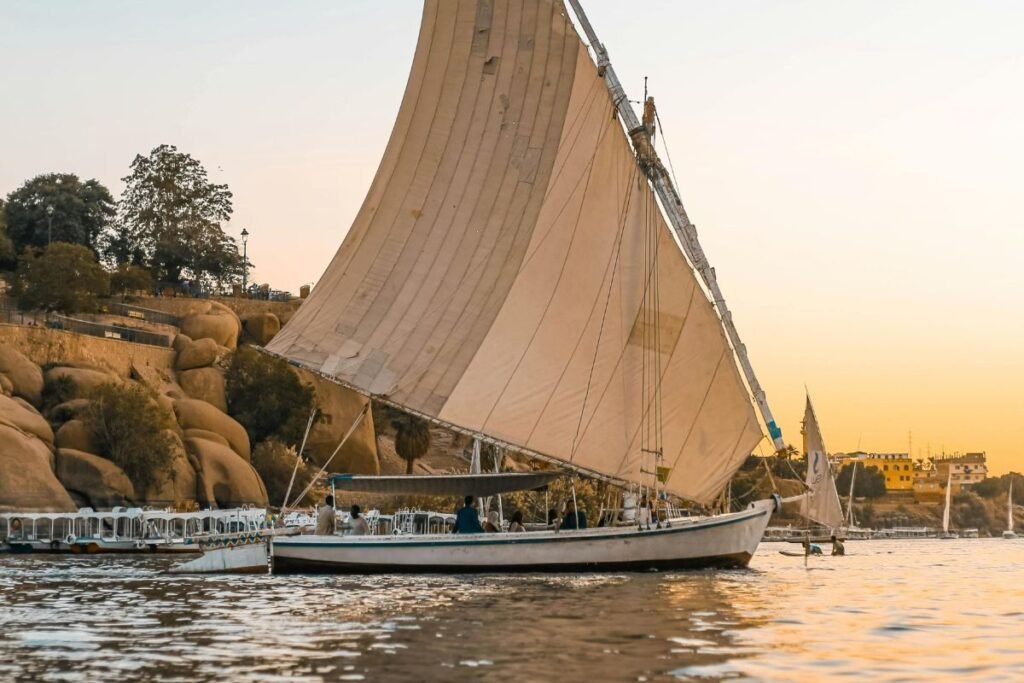 traditional felucca sailing boat on the Nile River at sunset in Aswan Egypt
